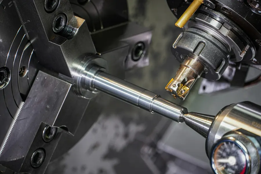 Máy tiện CNC đang tiện một trục thép