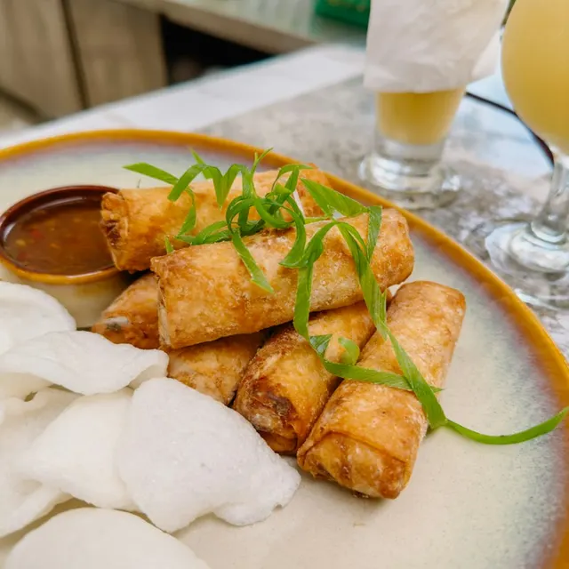 Chả giò chiên vàng bày trên đĩa cùng bánh phồng tôm