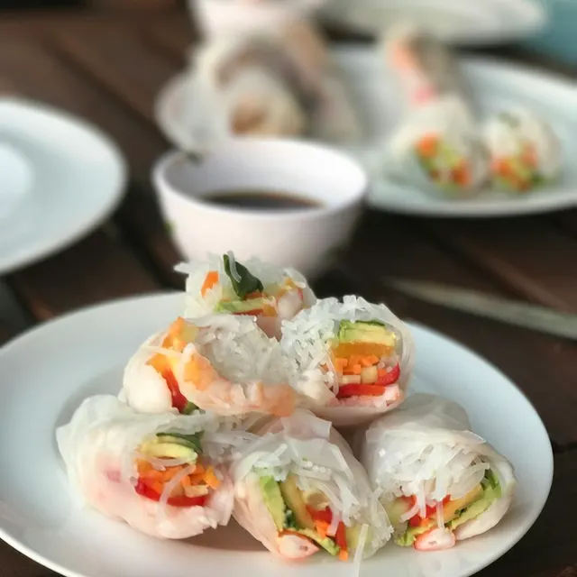 Gỏi cuốn tôm rau trên đĩa trắng kèm chén nước chấm